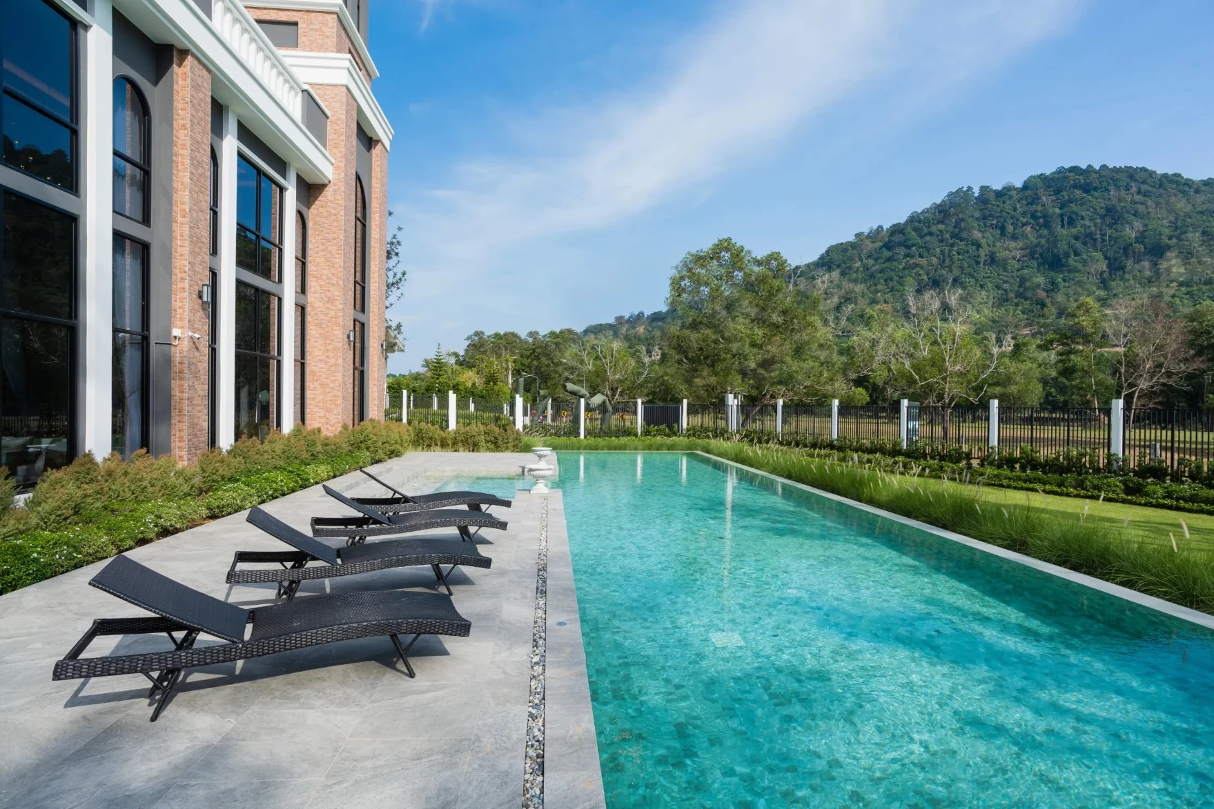 Crown Estate communal swimming pool with sun loungers in Koh Kaew Phuket